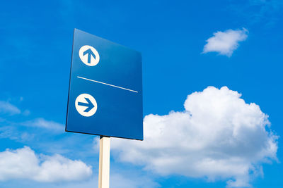 Low angle view of road sign against blue sky