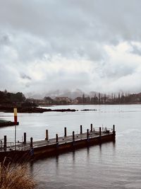 Pier on lake against sky