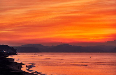 Scenic view of sea against orange sky during sunrise