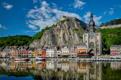 Reflection of buildings on mountain against sky