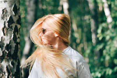 Portrait of woman standing against tree