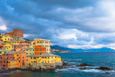 Buildings by sea against sky in city