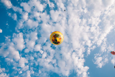 Low angle view of balloons flying against sky