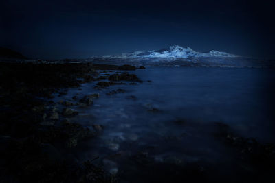 Scenic view of sea and mountains at night