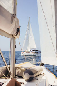 Sailboats sailing in sea against sky