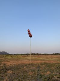 Flag on field against clear sky