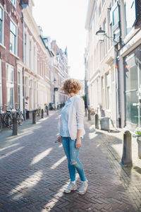 Rear view of woman walking on footpath in city