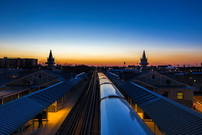 High angle view of train at illuminated railroad station against sky