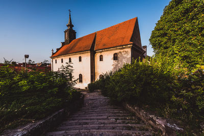 Walkway amidst buildings against sky