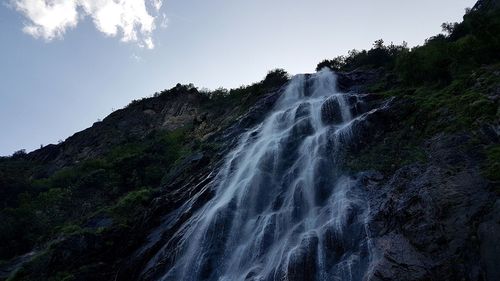Scenic view of waterfall in forest against clear sky