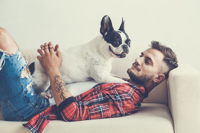 Man with dog on sofa against white background