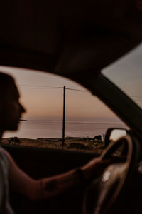 Man driving car during sunset