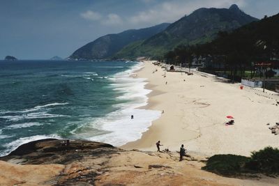 Scenic view of beach and mountains against sky