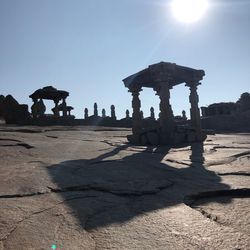 People at temple against clear sky on sunny day