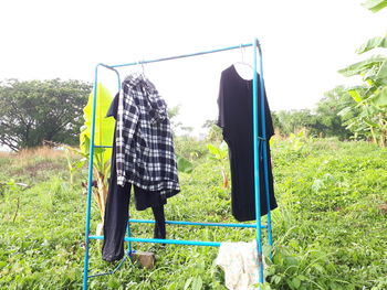 Clothes drying on field against sky
