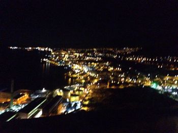 Illuminated cityscape against clear sky at night