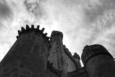 Low angle view of old building against cloudy sky