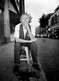 Portrait of a man sitting on built structure