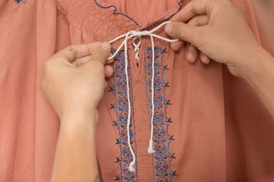 Cropped hands tying top bow