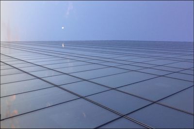 Low angle view of modern building against blue sky