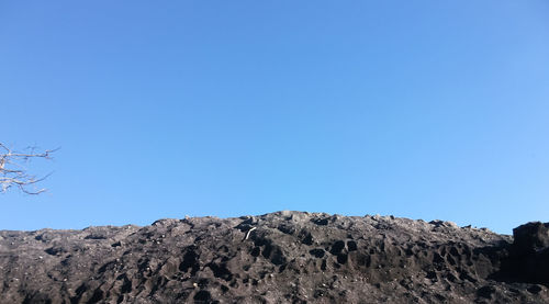 Low angle view of mountain against clear blue sky