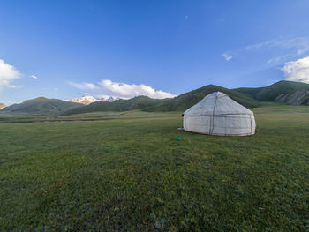 Scenic view of field and mountains against sky