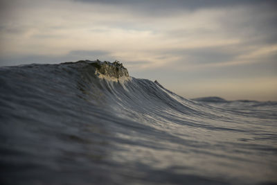 Scenic view of wave  against sky during sunset