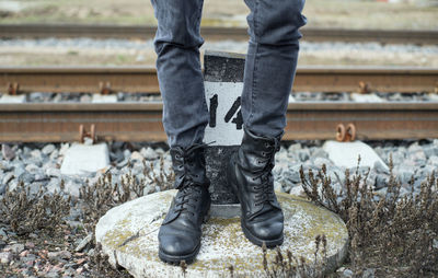 Low section of man standing by railroad tracks