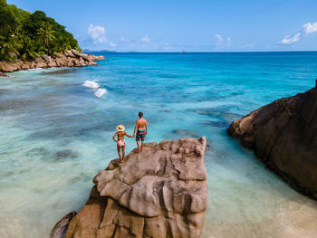 Rear view of people on beach against sky