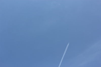 Low angle view of vapor trail against clear blue sky
