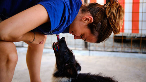 Side view of girl playing with dog