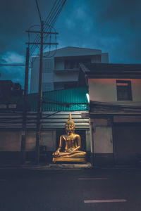 Statue outside building against sky at dusk