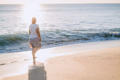 Rear view of woman standing on beach