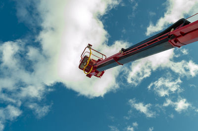 Low angle view of hydraulic platform against cloudy sky