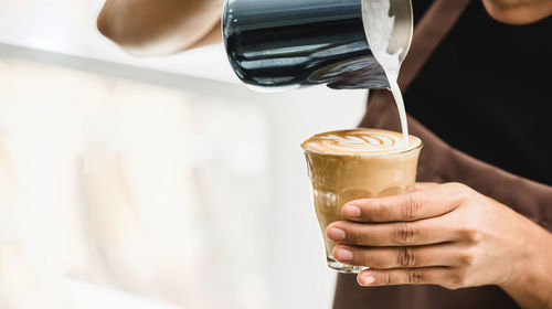 Cropped image of hand holding coffee cup