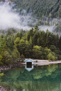 Deserted boat house by a lake with morning mist