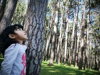 Side view of girl standing in forest