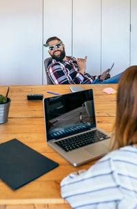 Midsection of woman using laptop at table