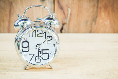 Close-up of alarm clock on wooden table