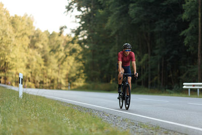 Muscular young man in sport clothing and protective helmet doing sport activity on bike 