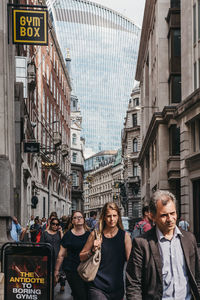 People standing on street against buildings in city