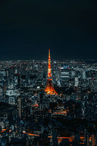 Illuminated buildings in city against sky at night