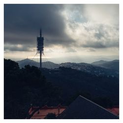 Communications tower and buildings against sky