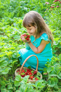 Rear view of young woman picking plants