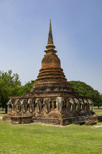 Ruined pagoda on field against clear blue sky