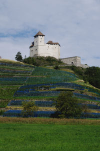 Building on field against sky