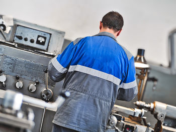 Rear view of man working in factory