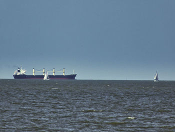 Boat sailing in sea against clear sky