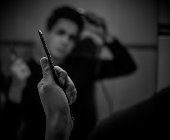 Reflection of man combing hair seen in mirror