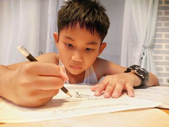 Portrait of boy holding ice cream on table